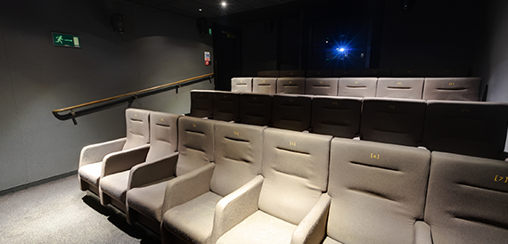 Cinema auditorium with cream reclining seats and dim ambient lighting