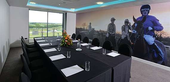 Boardroom with a long black table beneath a jockey silhouette mural