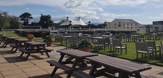 Outdoor terrace with picnic tables overlooking the racecourse