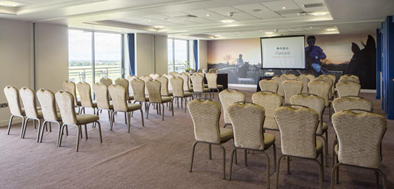 Conference room set theatre-style with wicker chairs facing the racecourse