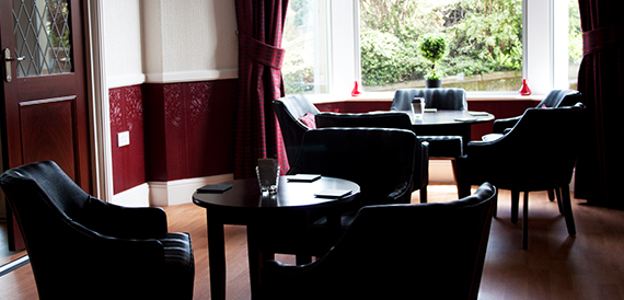 Lounge with black leather armchairs and red panelled walls