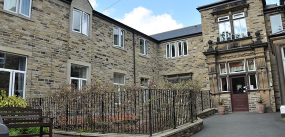 Stone building exterior viewed from a courtyard with railings