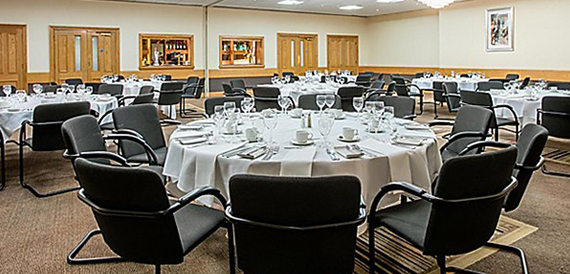Function room with round tables dressed in white linen for dining