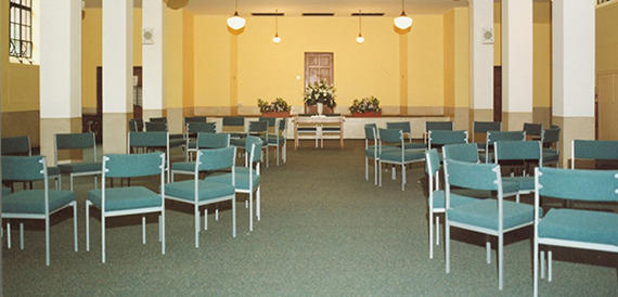 Meeting room with teal chairs arranged in a circle against yellow walls.