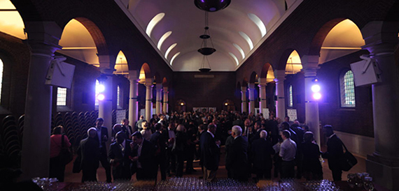 Domed hall filled with a seated crowd during an event lit in purple.