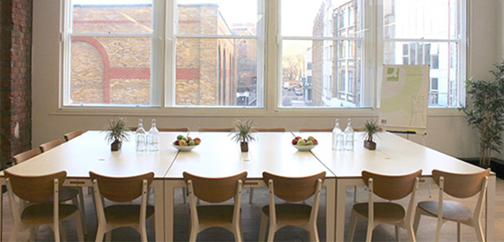 U-shaped meeting table with fruit bowls, water and a flip chart by the window