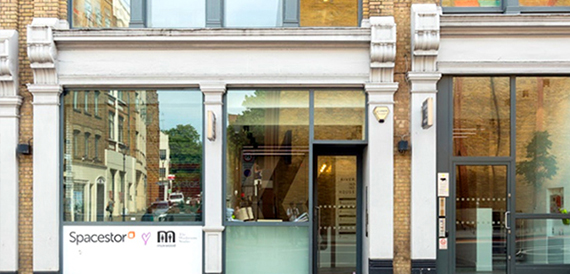Street-level entrance with glass doors and Spacestor signage on the brick facade
