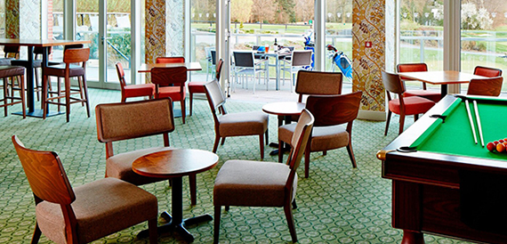 Bar lounge with a pool table, armchairs and golf course views