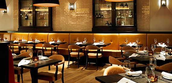 Restaurant dining area with tan booth seating and mustard upholstered chairs