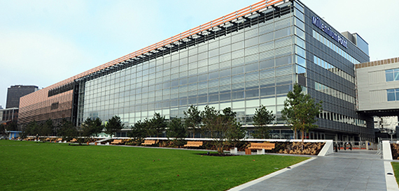Exterior of the glass-fronted Millennium Point building with landscaped lawns.