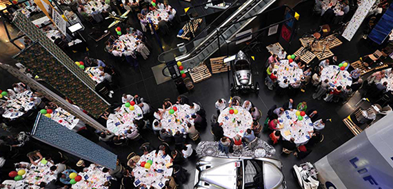 Aerial view of an exhibition event with round tables and balloon centrepieces in the atrium.