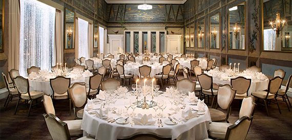 Ornate ballroom with a painted ceiling and a candlelit round table