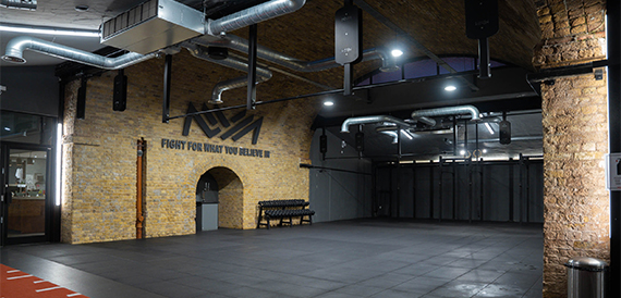 Empty gym hall with a motivational wall mural and weight racks