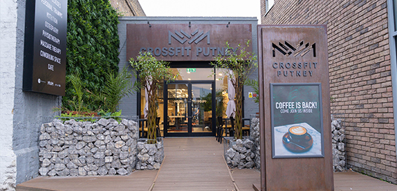 Crossfit Putney's brick entrance with glass doors and a landscaped walkway