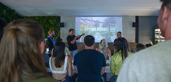 Group of people watching a presentation on a wall-mounted screen
