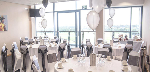 Function room with white balloons and grey chair sashes