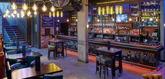 Bar counter with hexagon tiling, string lighting and high tables