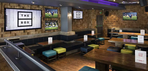 Lounge seating with colourful stools facing screens showing football