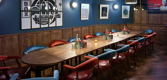 Long table with blue and red booth seating along a wall