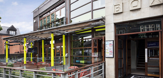 Glass shopfront with yellow structural pillars on a city street