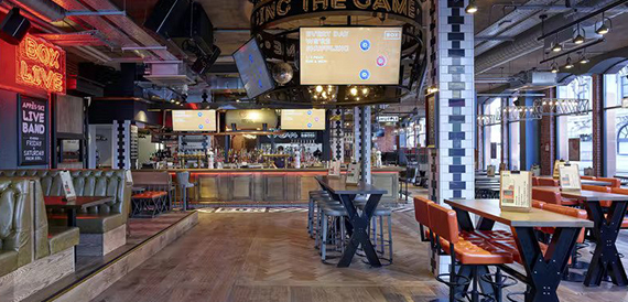 Games area with neon 'Box Live' signage and high tables