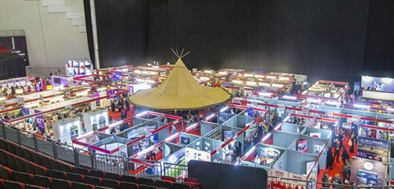 Aerial view of an exhibition hall with a central marquee tent and stands.