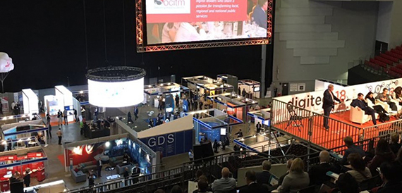 Aerial view of an exhibition floor with rows of trade stands and visitors.