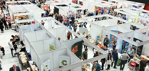 Aerial view of an exhibition hall with trade stands and visitors