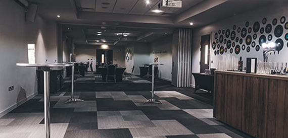 Dark lounge with high tables on a chequered floor