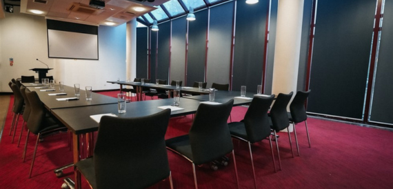 Meeting room set classroom-style with black chairs on a red carpet