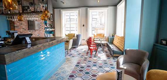 Bar lounge with a patterned tiled floor and red chairs