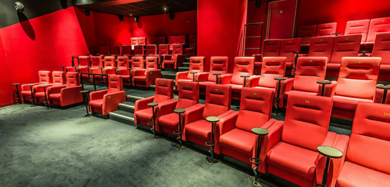 Screening room with red tip-up seats on a stepped floor
