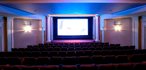 Cinema auditorium with blue ceiling lighting and classical columns