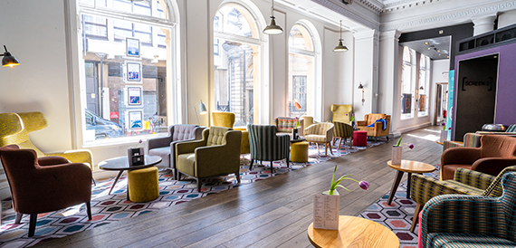 Bright lounge with arched windows and colourful mismatched armchairs