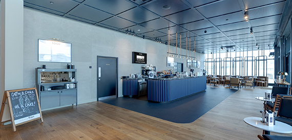 Bar counter with a chalkboard menu beneath floor-to-ceiling windows