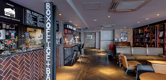 Bar area with box office signage, brick walls and high stools