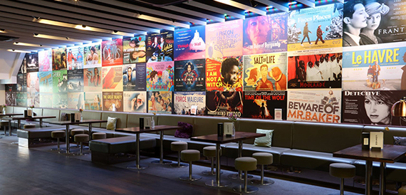Lounge with a wall of colourful film posters and banquette seating