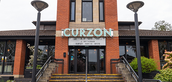 Close view of Curzon's illuminated signage above the entrance steps