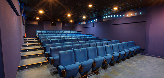 Cinema auditorium with blue seats and warm string lighting