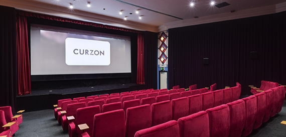 Cinema auditorium with red velvet seats and an art deco mirrored feature