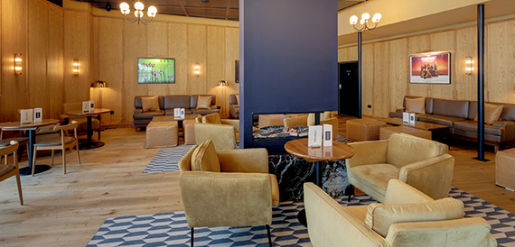 Lounge with mustard armchairs, wood panelling and chandeliers