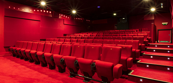 Cinema auditorium with red seats on an illuminated stepped aisle