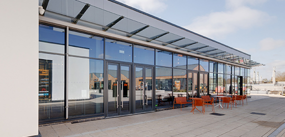 Glass-fronted exterior entrance beneath a covered canopy roof