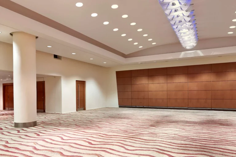 Beatrice Suite empty ballroom with wood-panelled walls, a pendant light fixture and patterned carpet.