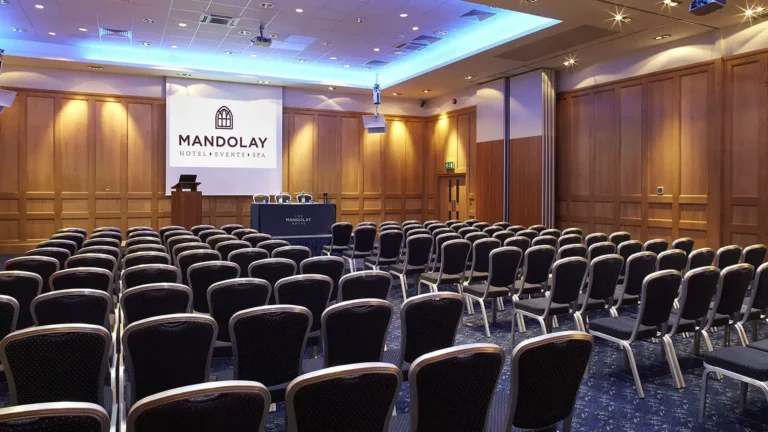 Castle Room set theatre-style with rows of black chairs facing a lectern