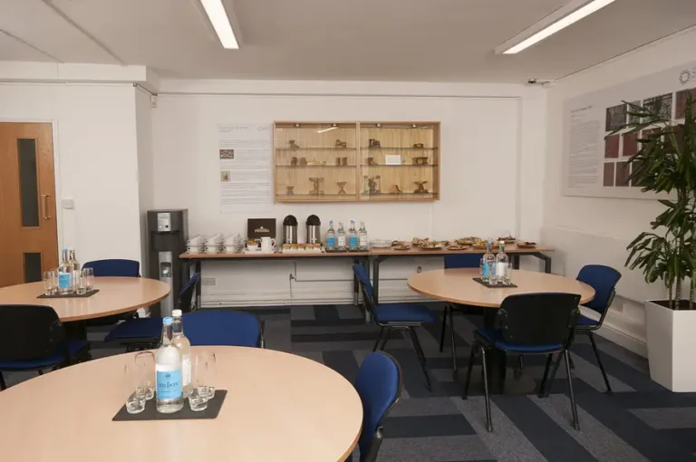 Catering area with round tables and a wall display cabinet