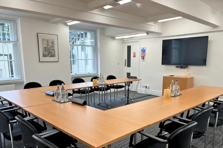 Cayley Room set U-shaped with a wall-mounted screen and wood flooring