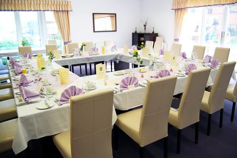 Long dining tables set with purple napkins and formal place settings