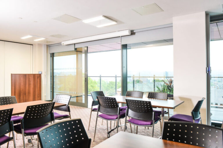 Discovery Room with purple chairs and glass doors opening to a balcony
