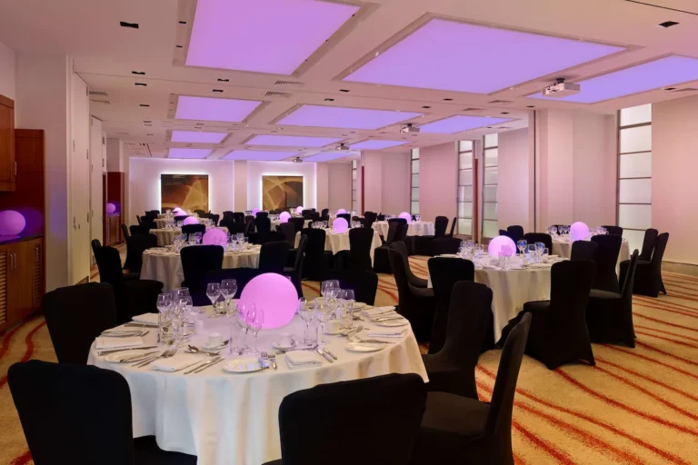 Edward Suite set for a banquet with round tables, black chair covers and glowing orb centrepieces.